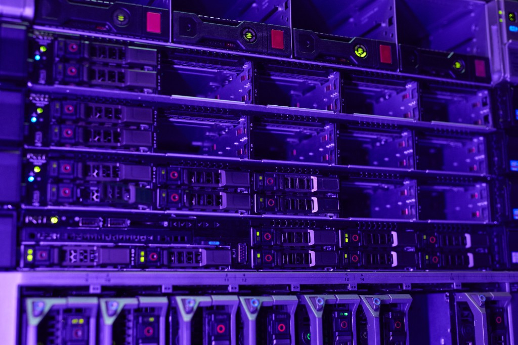 Two professionals shaking hands in front of a data center